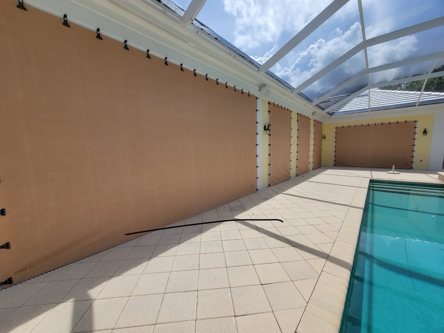 AstroGuard fabric panels deployed along a screened pool enclosure
