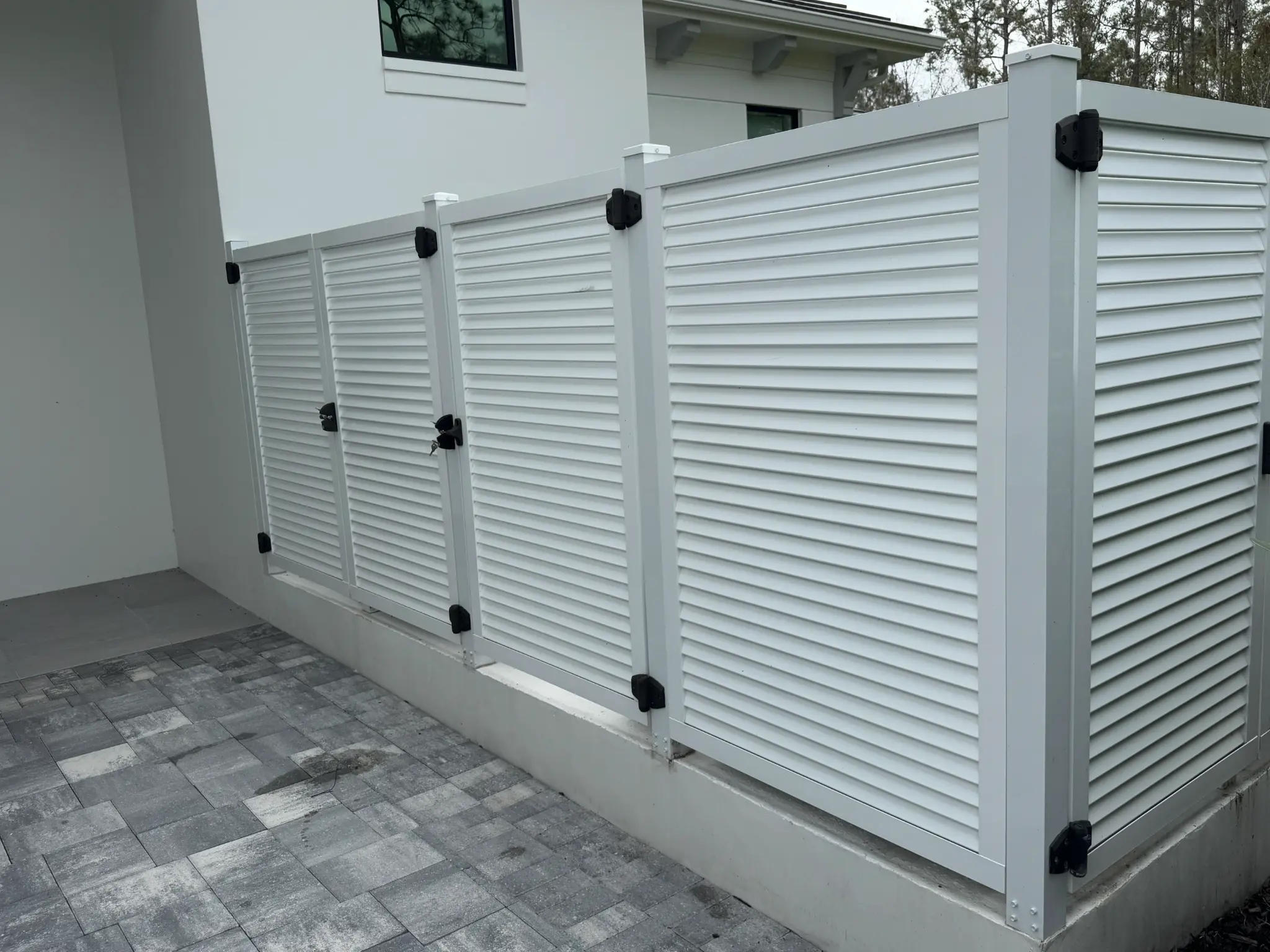 White louvered gate panels with black hardware