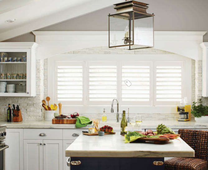 White plantation shutters installed in a kitchen window above the sink in a Naples home