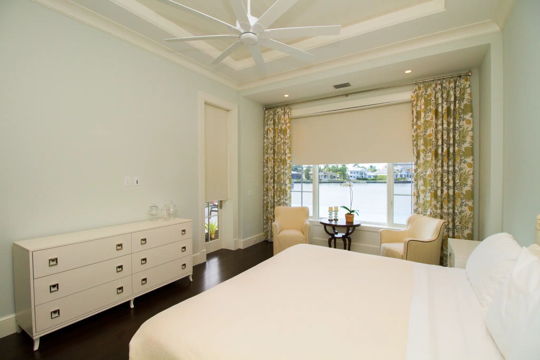 Roller shades at waterfront bedroom windows